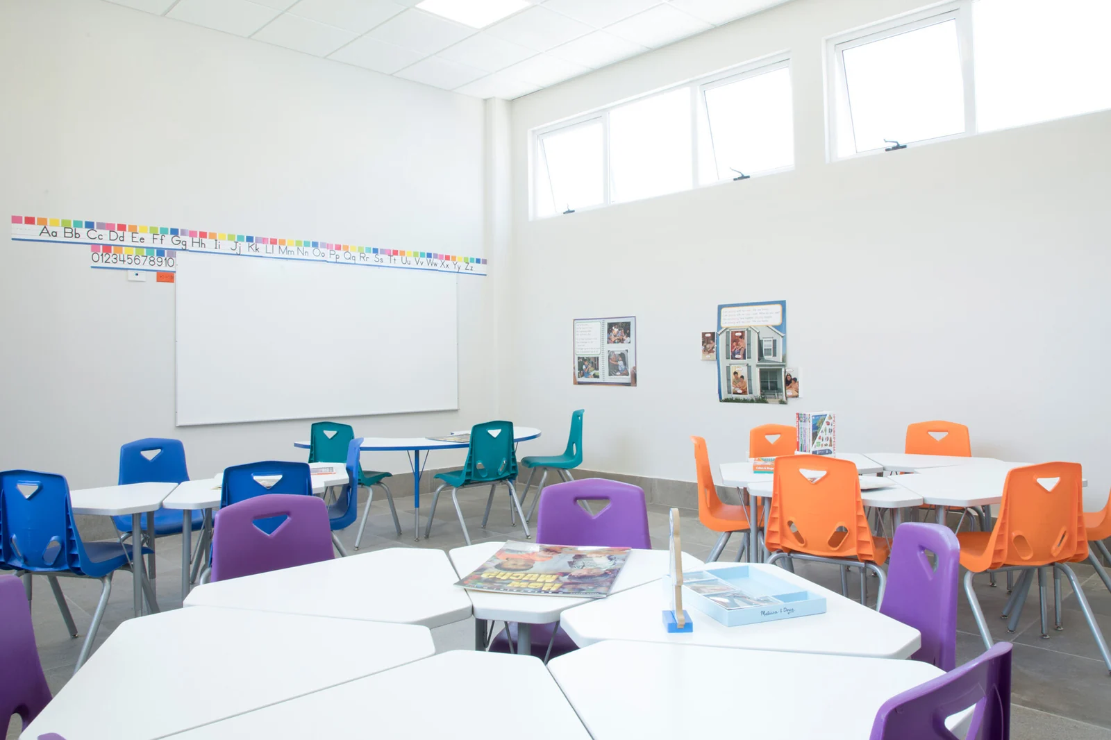 Spacious classroom with large windows and colorful tables and chairs