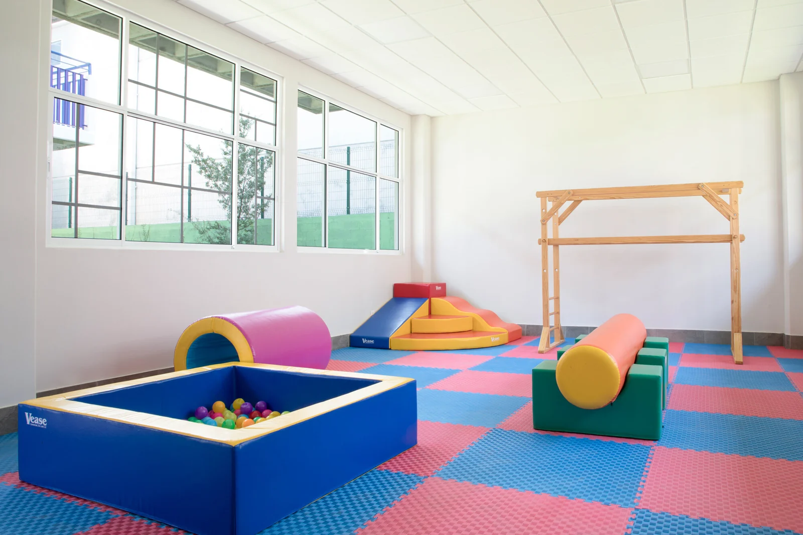 Motor skills room with foam play modules and a colorful mat