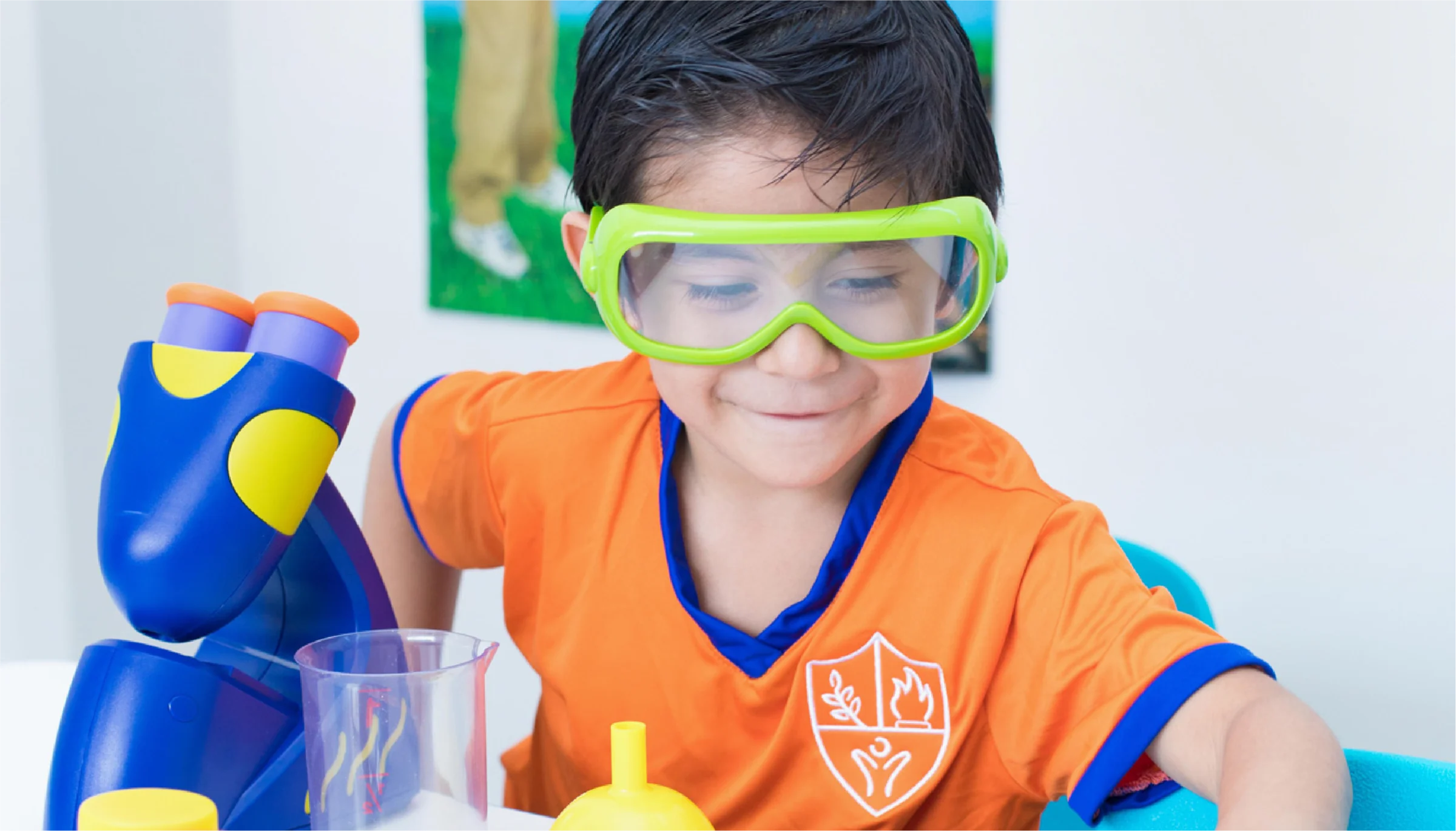 Instituto San Gerardo boy wearing lab goggles exploring a toy microscope